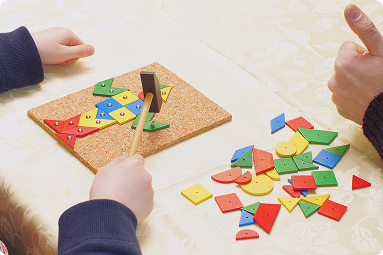 Occupational therapist helping child building with blocks